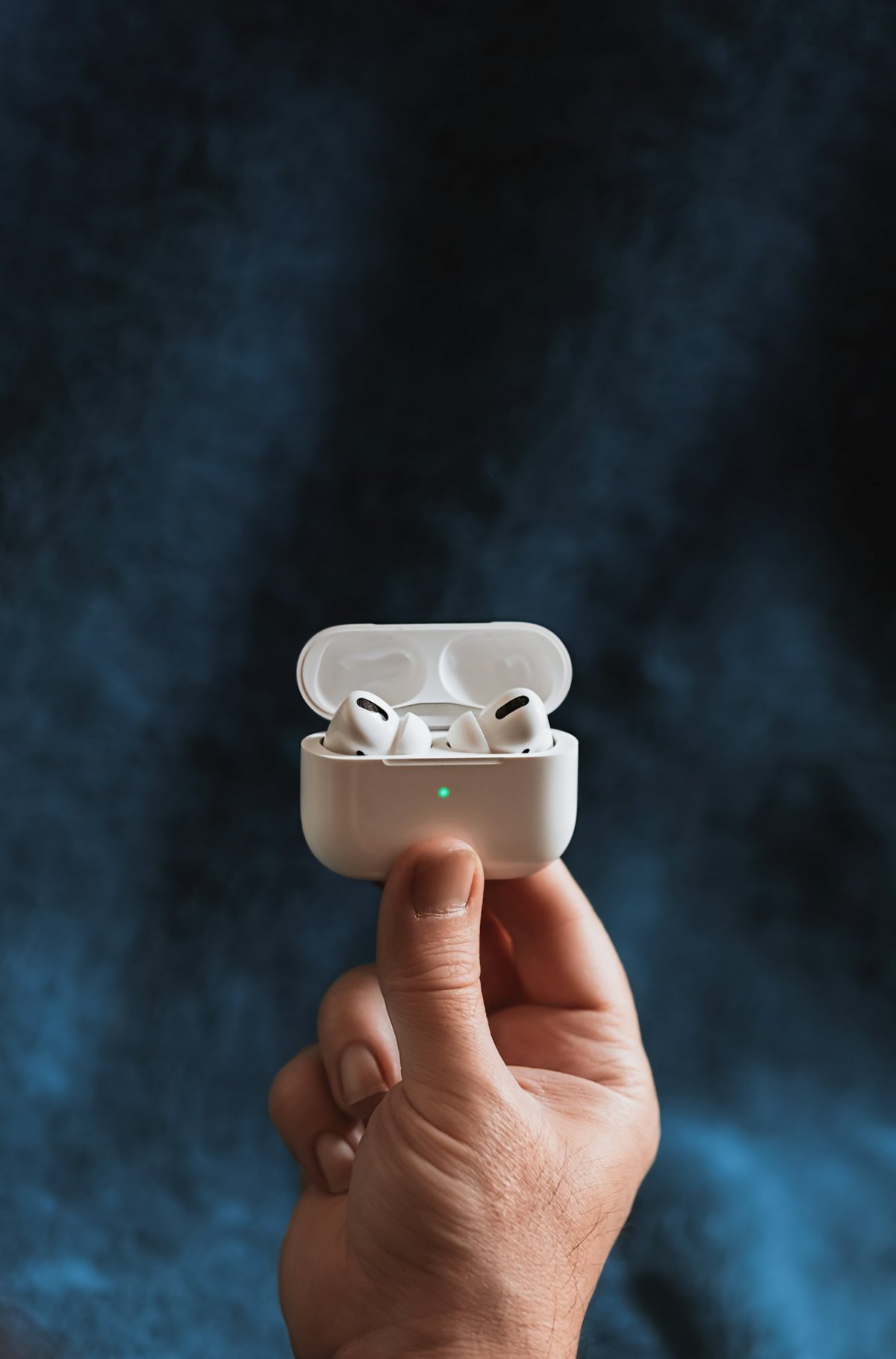 Apple AirPods Pro 3 blancs posés sur un fond rose avec leur boîtier de chargement MagSafe